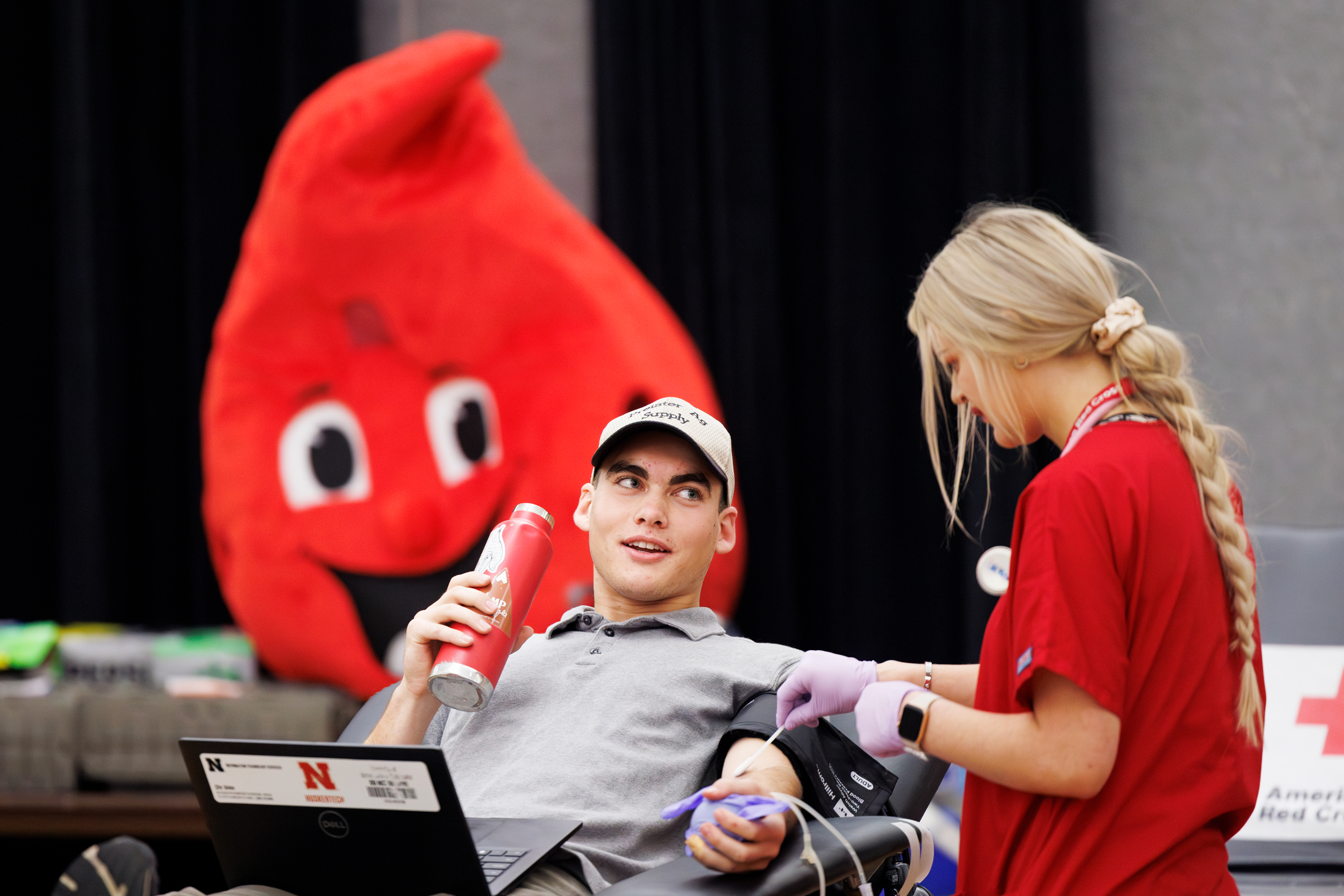 Student giving blood at the annual Homecoming Blood Drive