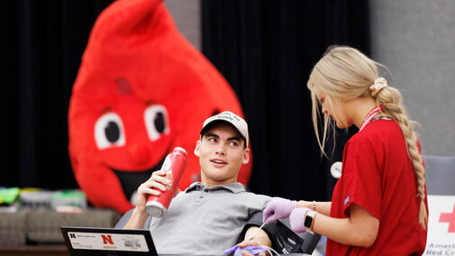 Student talks to another while donating blood