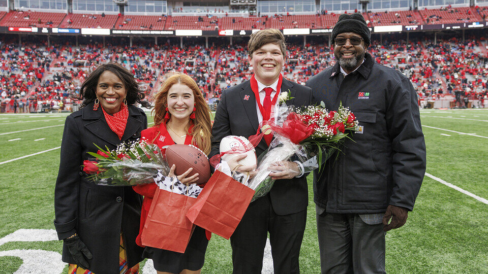 Newly crowned homecoming royalty Hannah-Kate Kinney (second from left) and Preston Kotik (third from left) are joined by Chancellor Rodney Bennett (right) and his wife, Temple (left), during the halftime ceremony. (photo by Craig Chandler | University Communication and Marketing) 