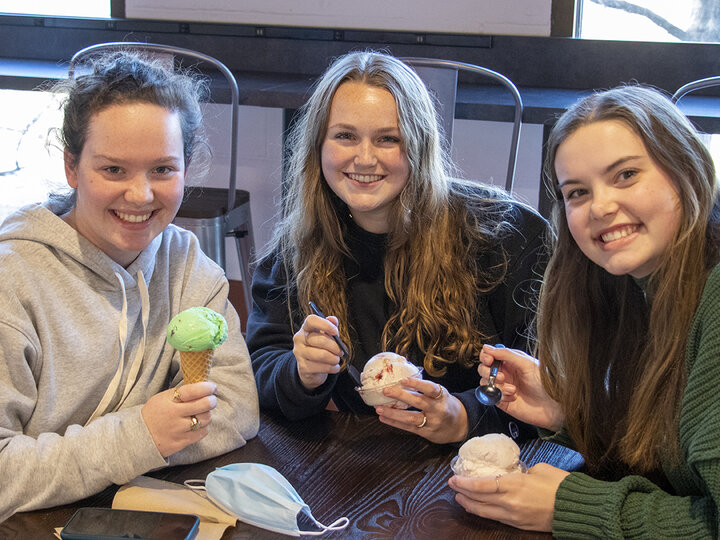 Three students eat ice cream at the Dairy Store on East Campus [photo by Mike Jackson | Student Affairs]
